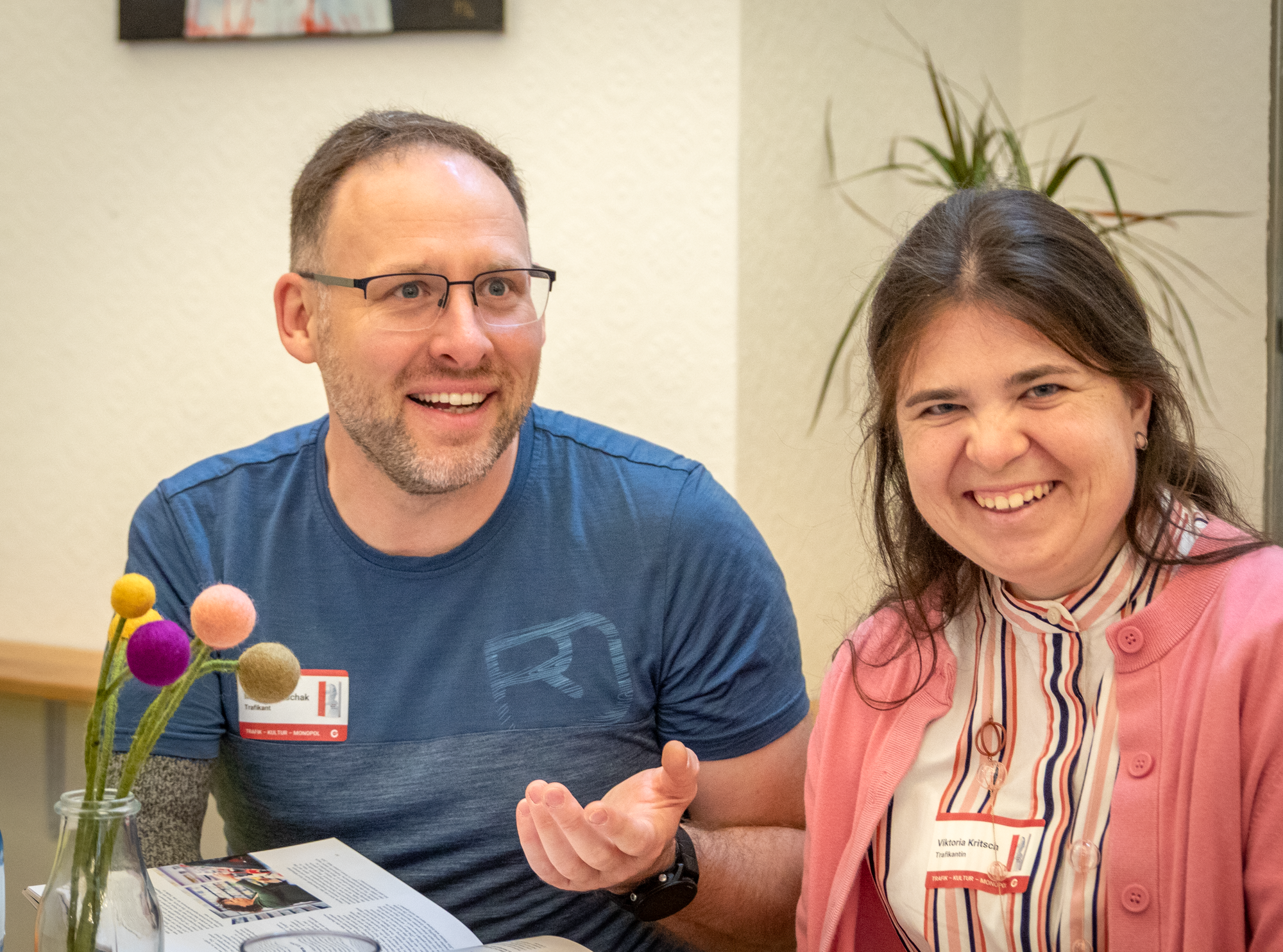 Eine Trafikantin und ein Trafikant lächeln in die Kamera