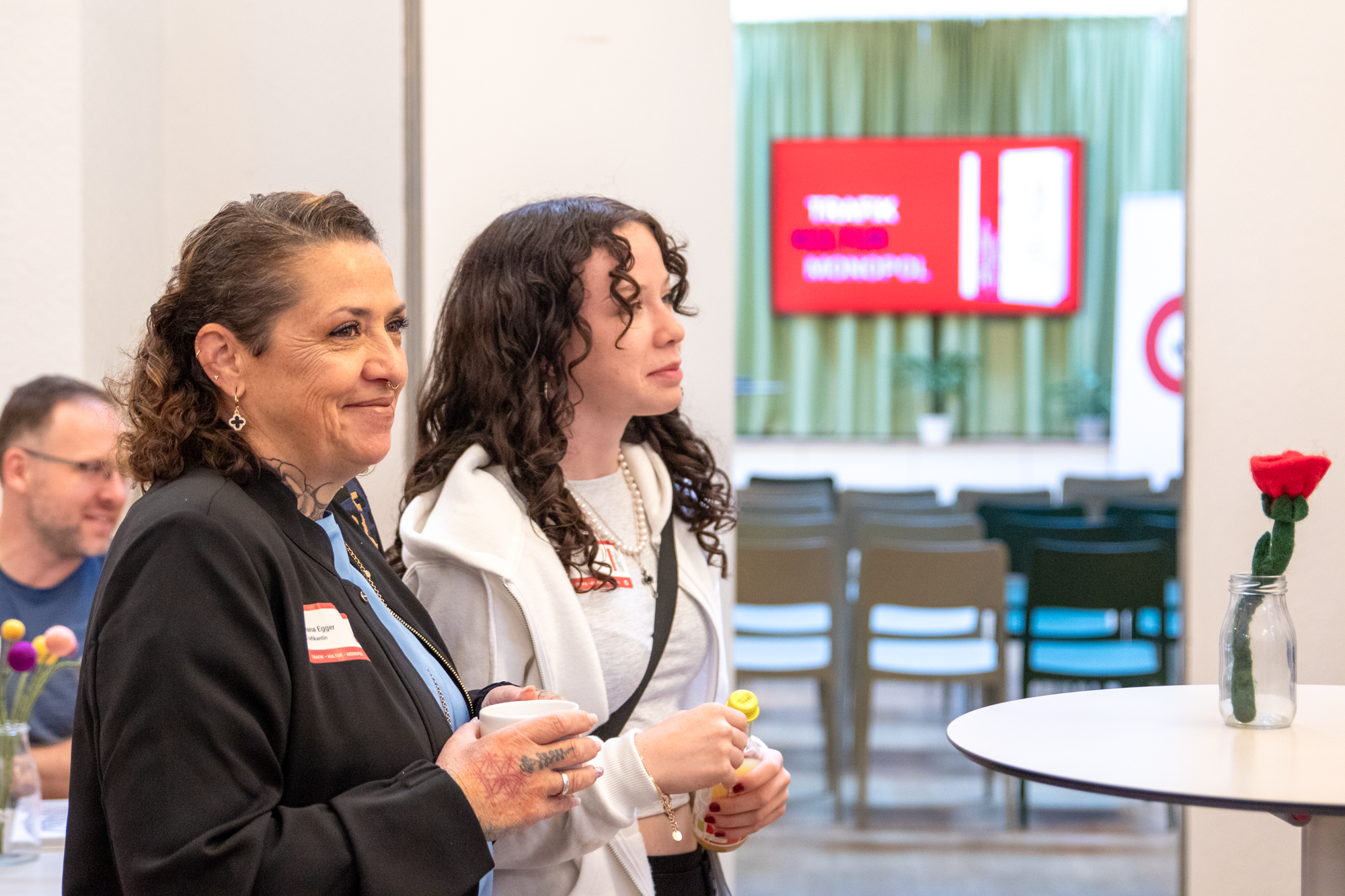 Zwei Frauen, eine mit einem blauen Oberteil und einer schwarzen Jacke, die andere Dame trägt ein weißes Leiberl mit einer weißen Weste