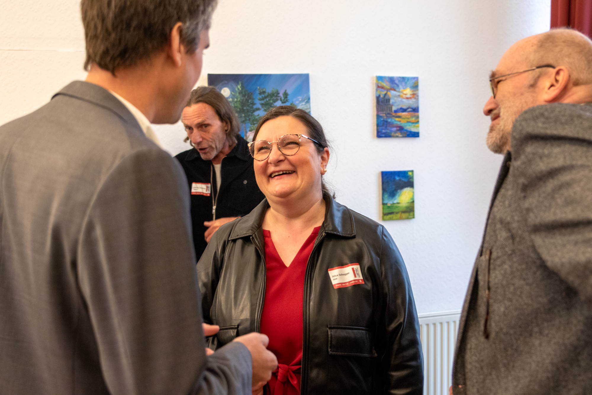 Zwei Monopolstellenleiter der MVG reden mit einer Frau mit einem roten Oberteil und einer Lederjacke