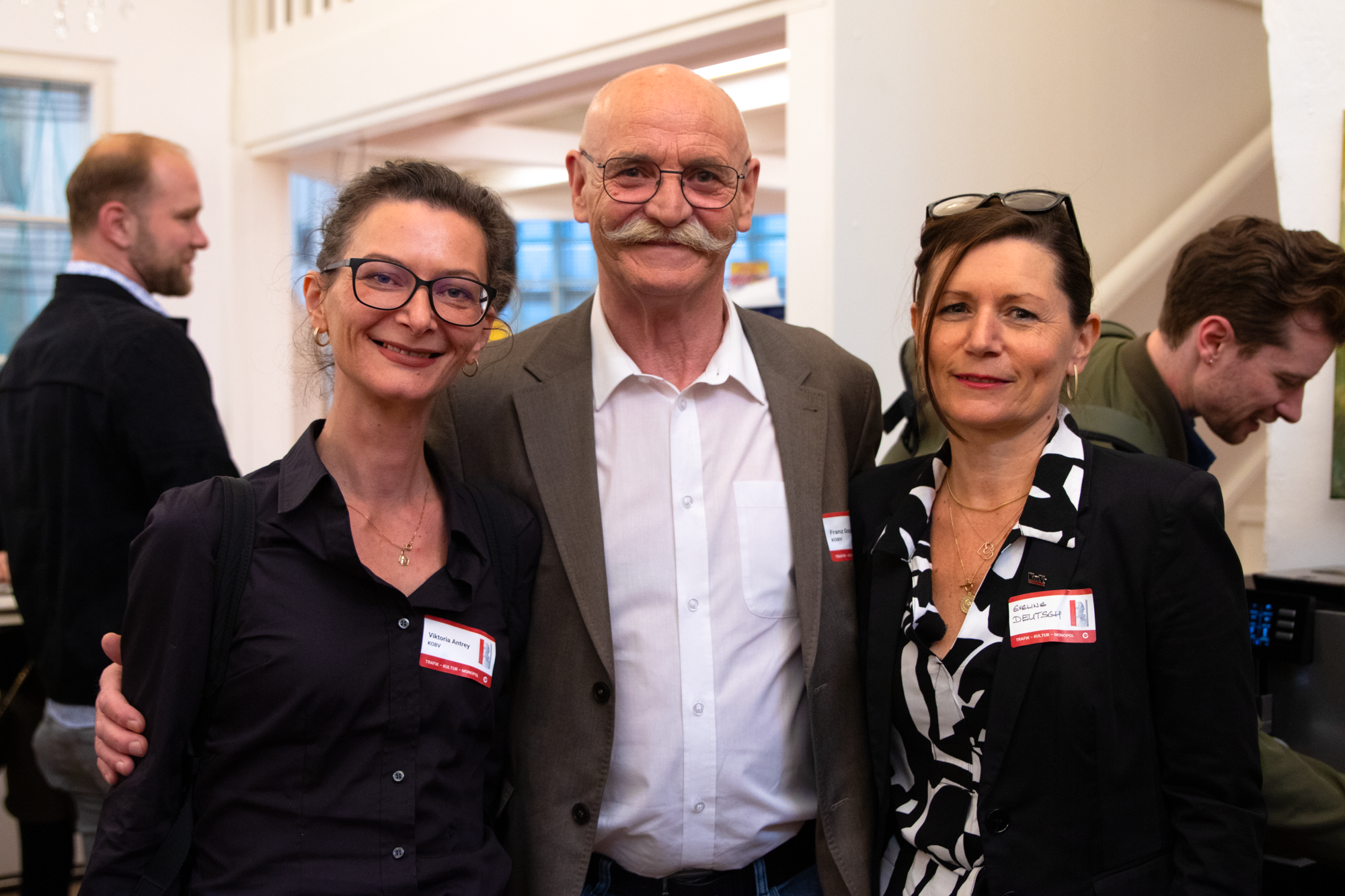 Ein Mann steht zwischen zwei Frauen und alle schauen in die Kamera