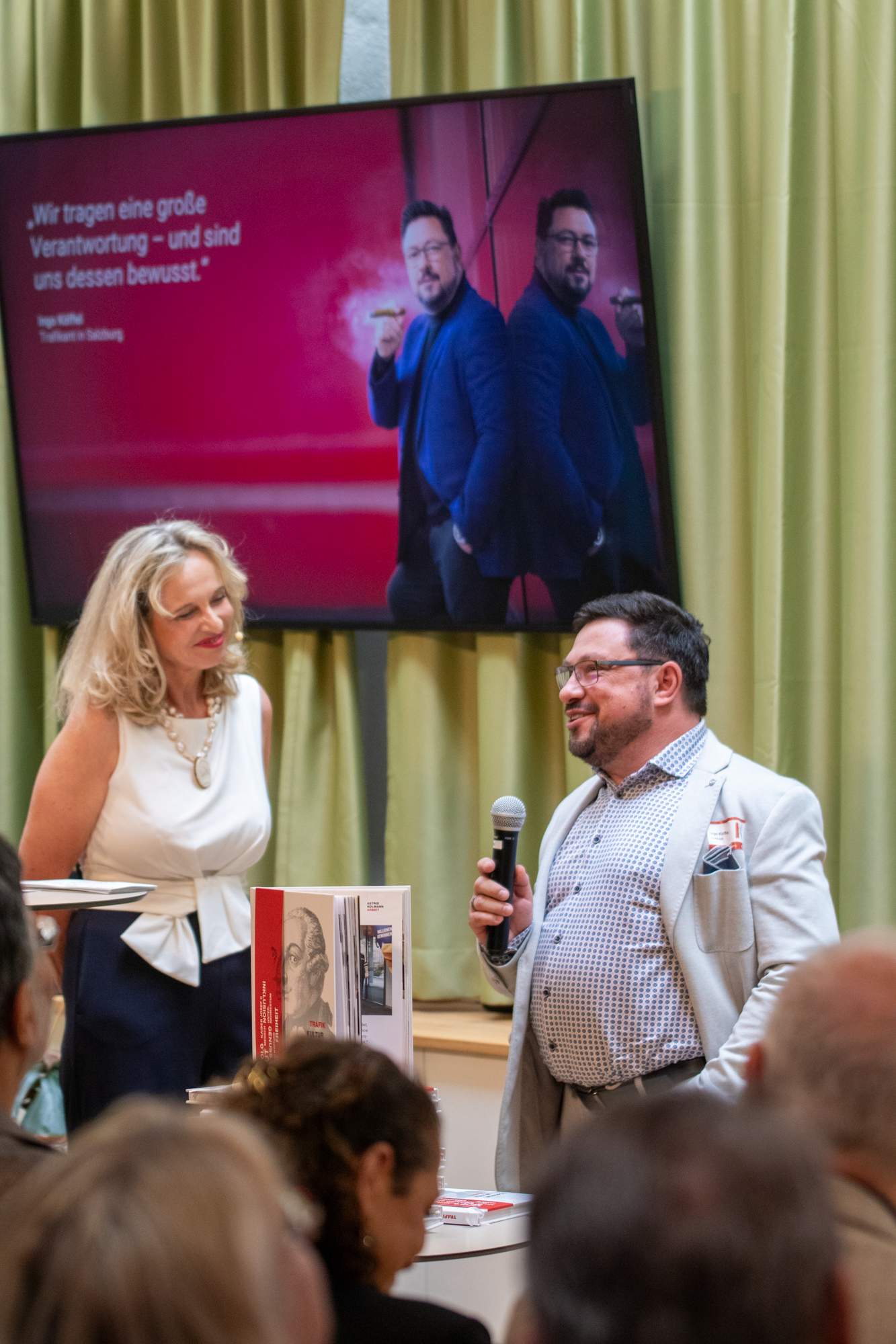 Monopolstellenleiterin steht mit Trafikanten auf der Bühne der aus seinem Leben erzählt