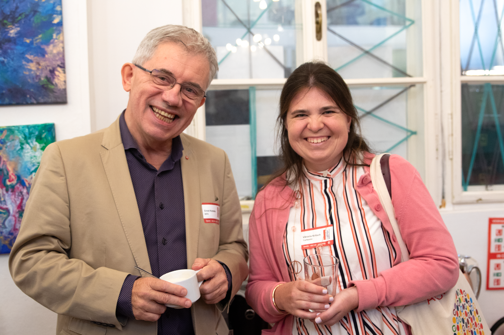 Monopolstellenleiter steht neben Trafikantin und beide lächeln in die Kamera