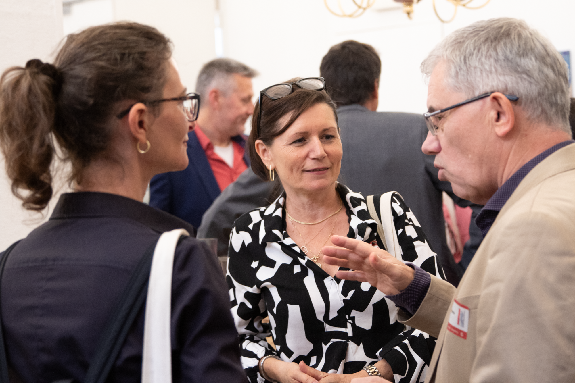 Der Monopolstellenleiter unterhaltet sich mit zwei Frauen über das Event