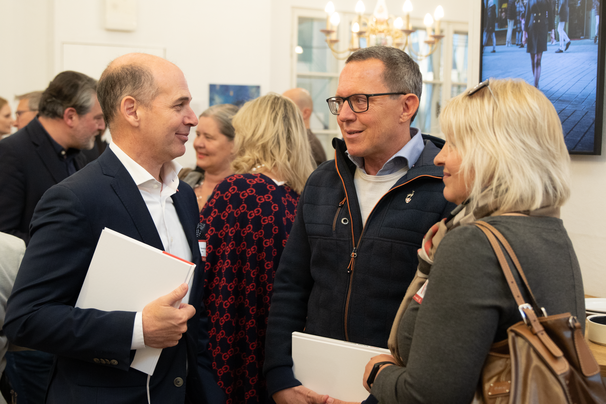 Der Geschäftsführer der MVG unterhaltet sich mit zwei Besuchern der Buchvorstellung