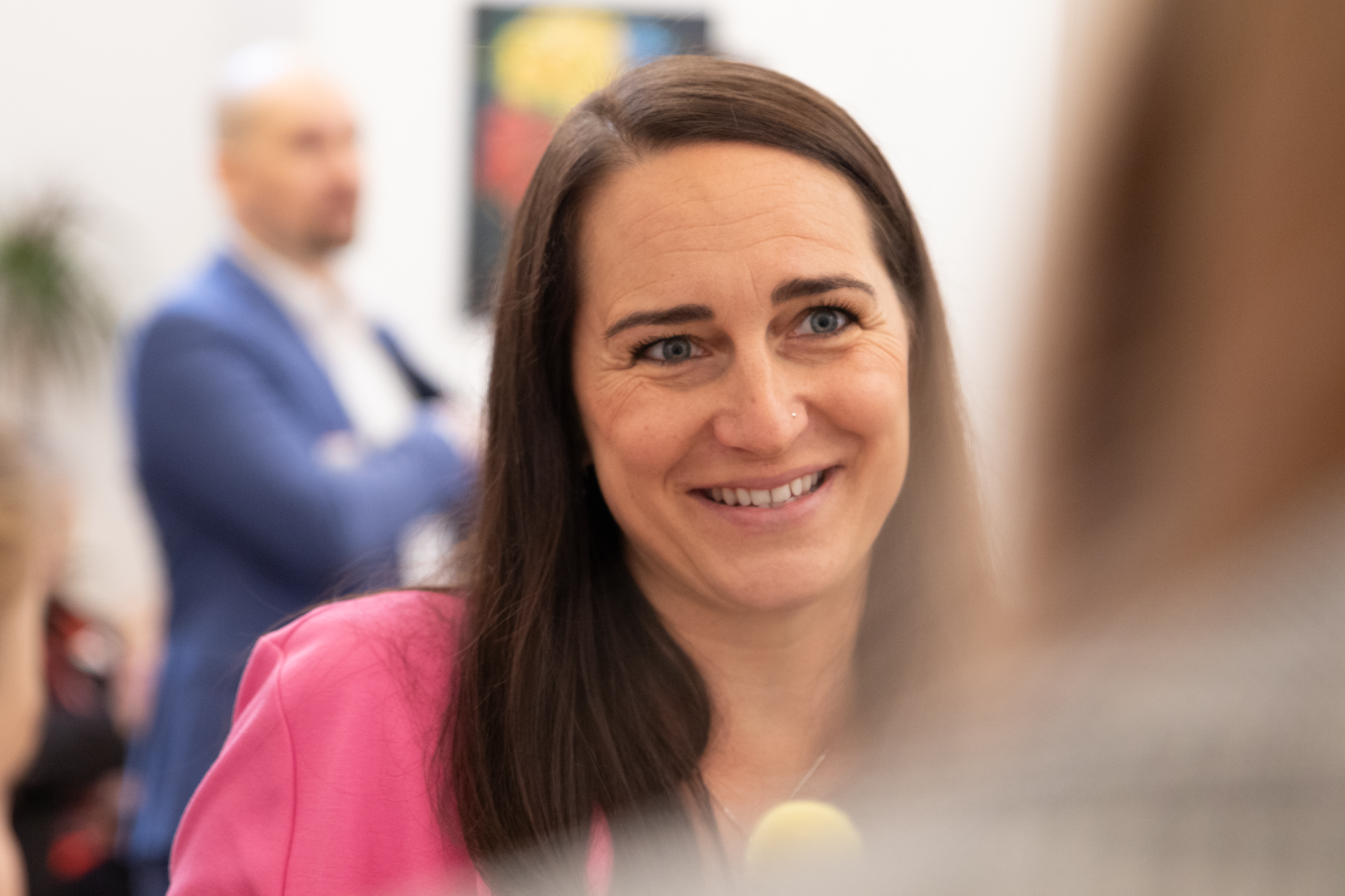 Brünette Frau mit pinken Oberteil unterhaltet sich mit einer MVG Mitarbeiterin 