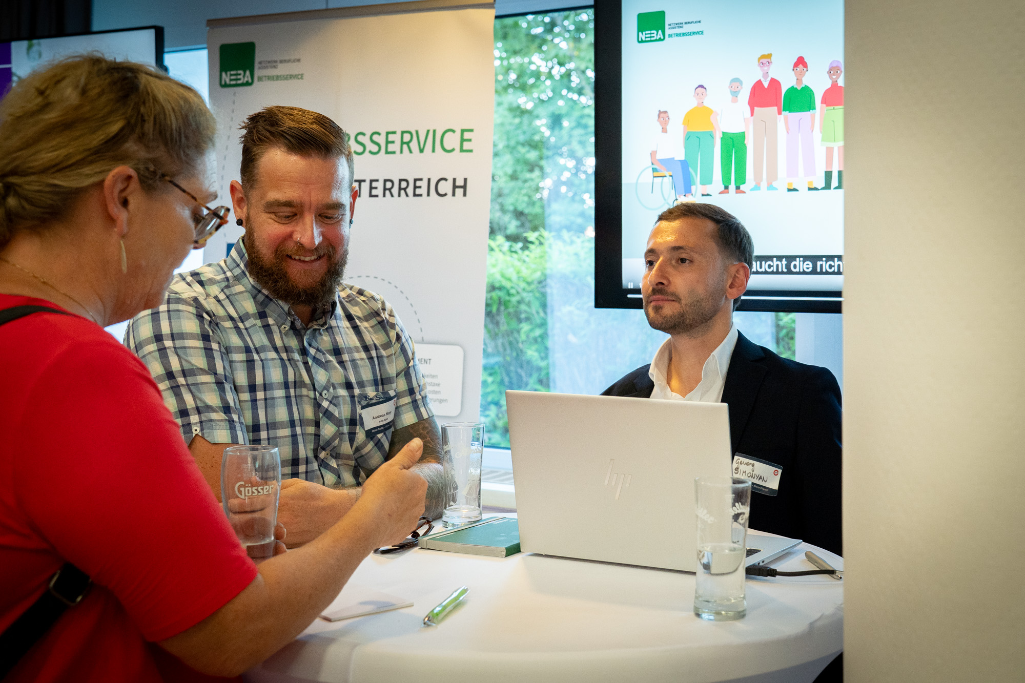 Eine Interessentin unterhaltet sich mit zwei Organisationspartnern der Firma Neba