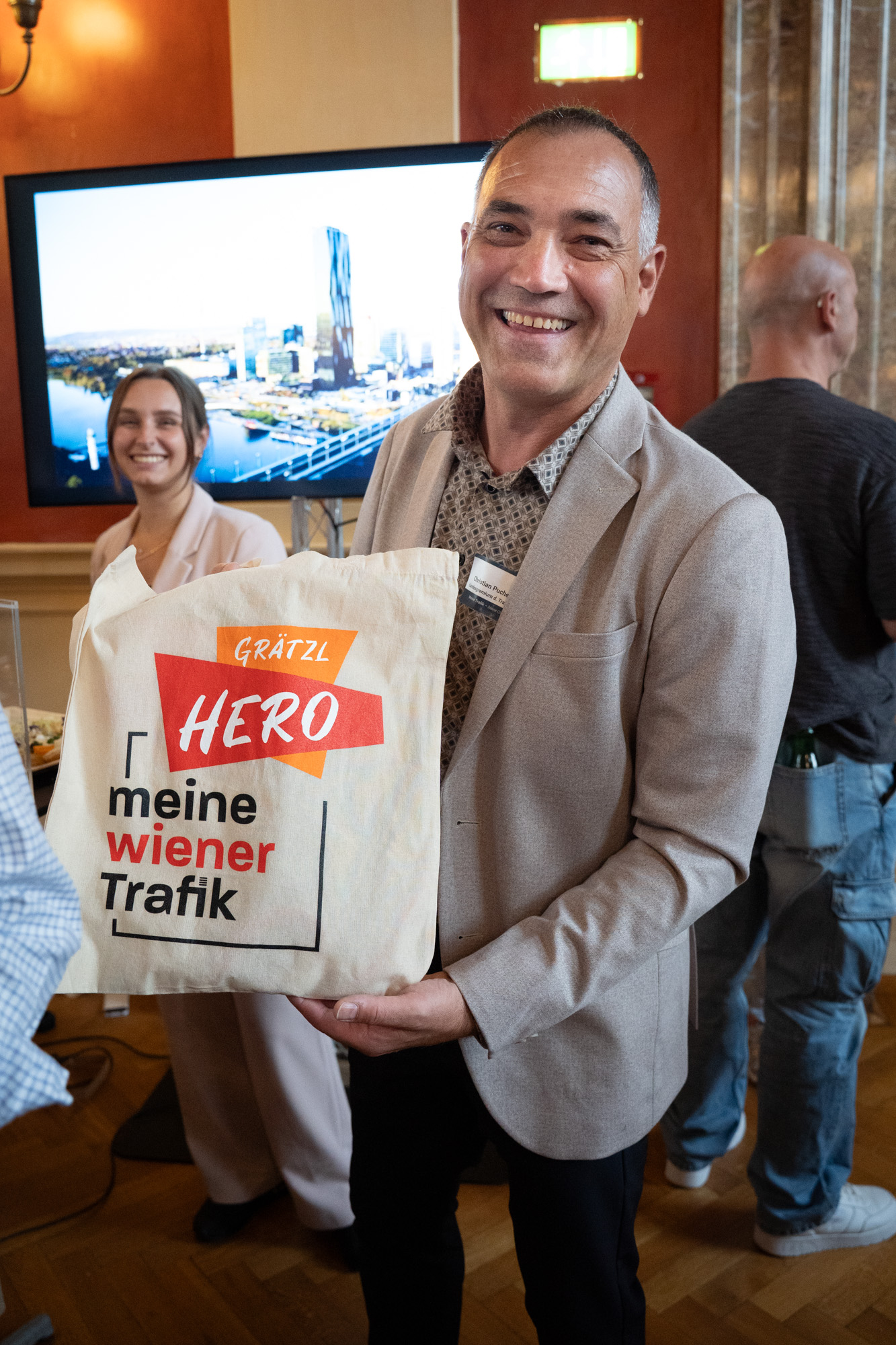 Trafikantenvertreter präsentiert einen Jutebeutel mit der Aufschrift "Grätzl Hero meine wiener Trafik"