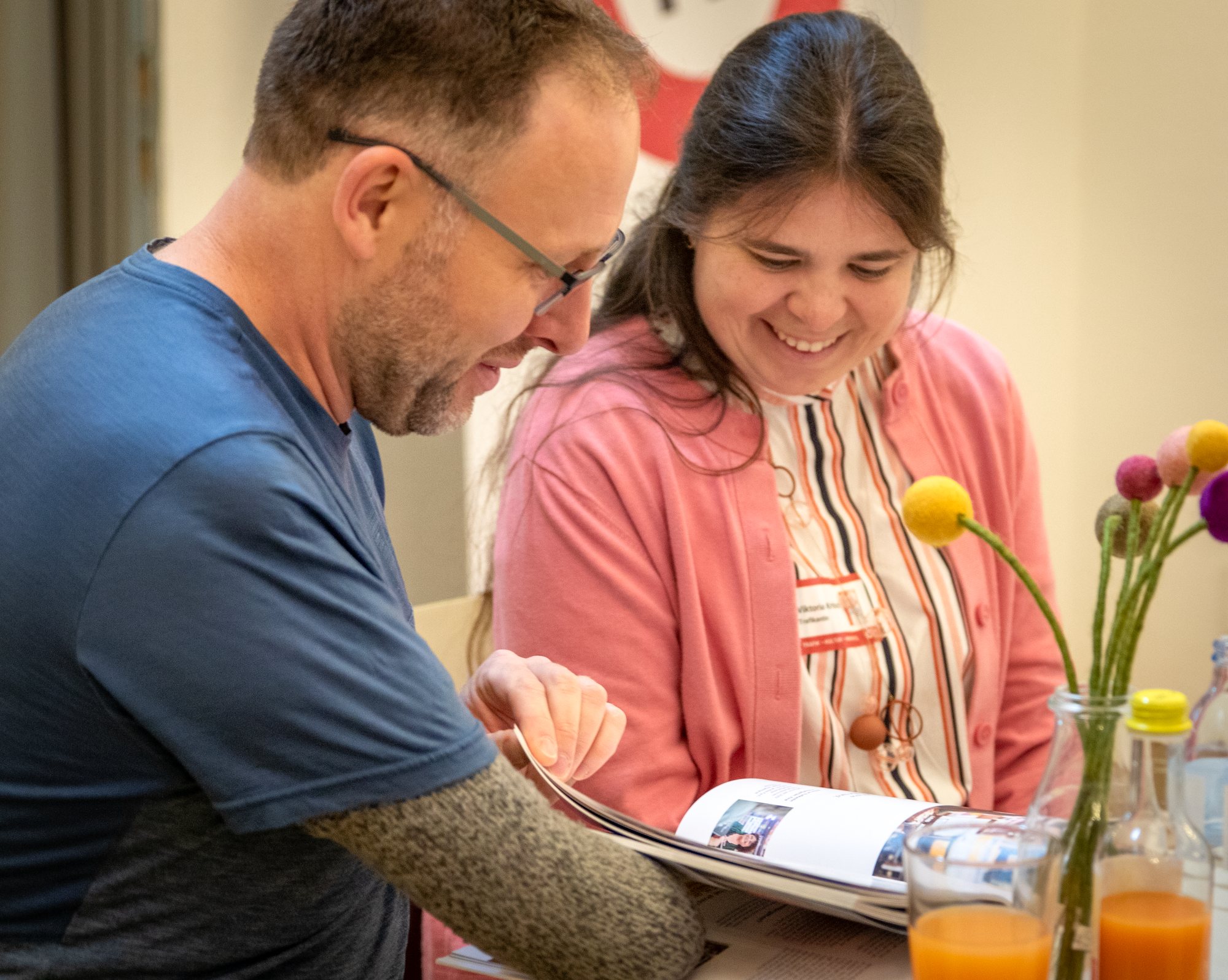 Eine Trafikantin und ein Trafikant blättern durch das Trafikbuch
