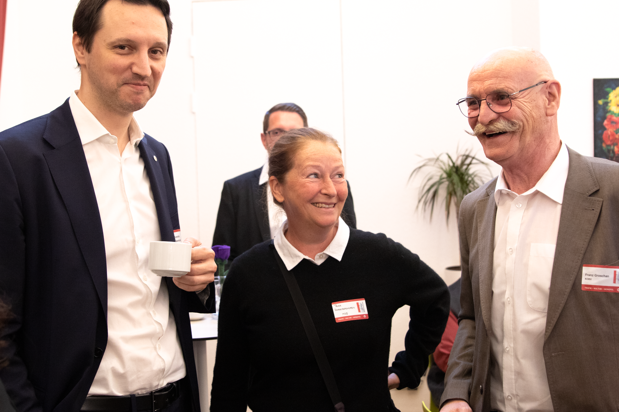 Drei Personen stehen nebeneinander, eine Frau zwischen zwei Männern