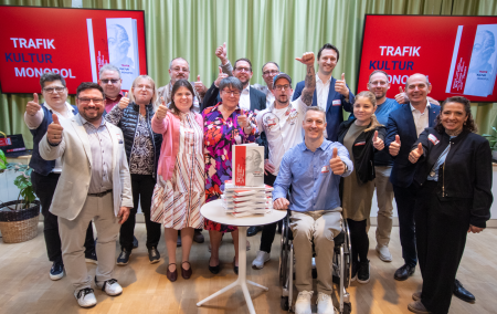 Ein Ein Gruppenfoto der Trafikanten und Trafikantinnen, die im Trafikbuch beschrieben werden, die einen Daumen nach oben zeigen