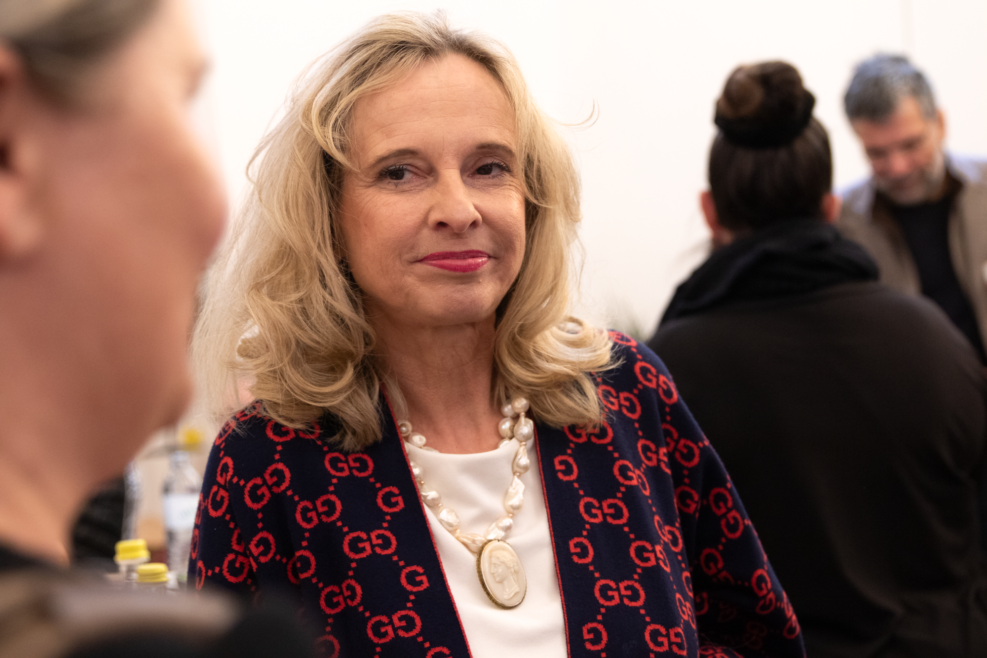 Nahaufnahme einer Monopolstellenleiterin mit rot-schwarzen Sakko und weißen Oberteil