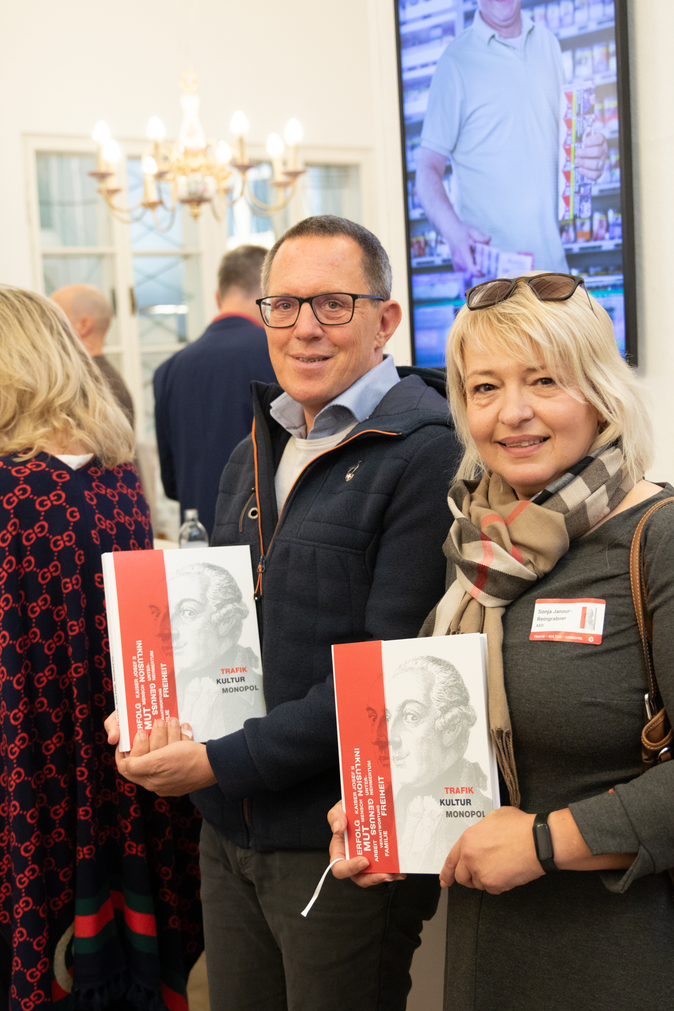 Zwei Besucher der Buchvorstellung präsentieren ihr Buchexemplar