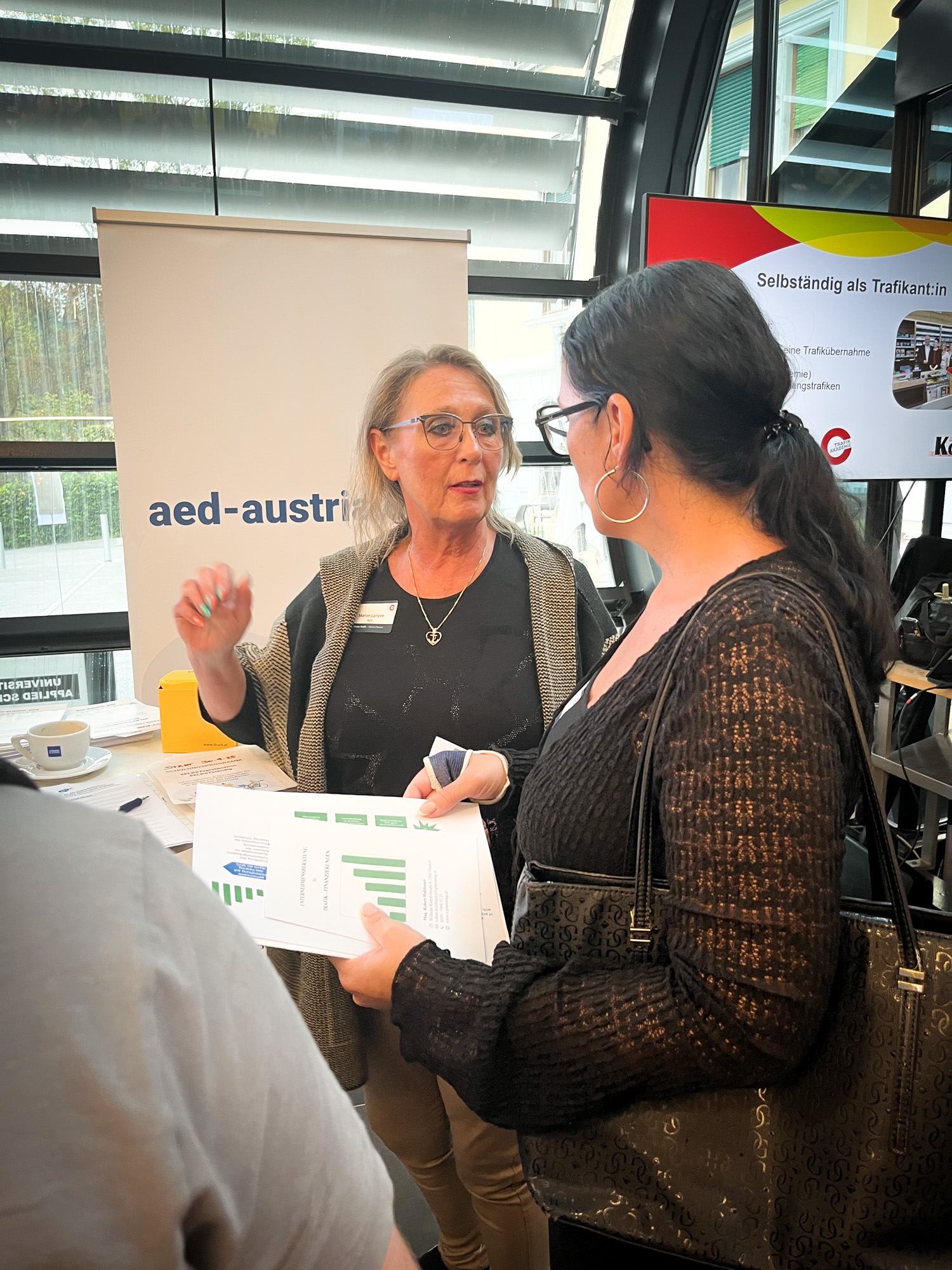 AED Mitarbeiterin unterhält sich mit einer Interessentin 