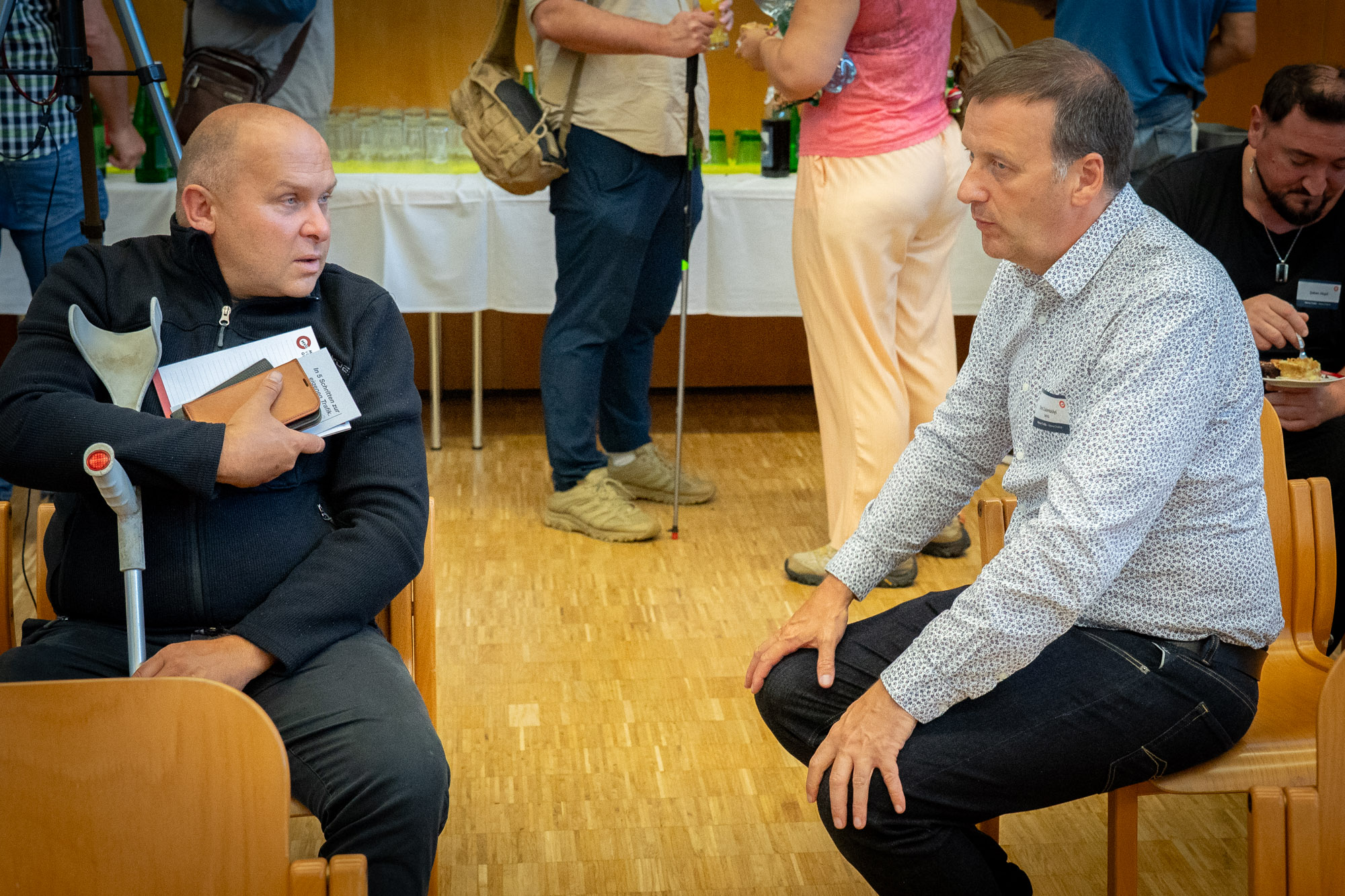 Ein Außendienstmitarbeiter der MVG unterhält sich mit einem Interessenten mir einer Krücke