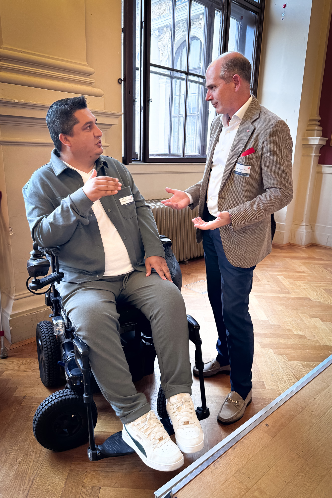 Geschäftsführer der MVG unterhält sich mit einem Interessent im Rollstuhl 