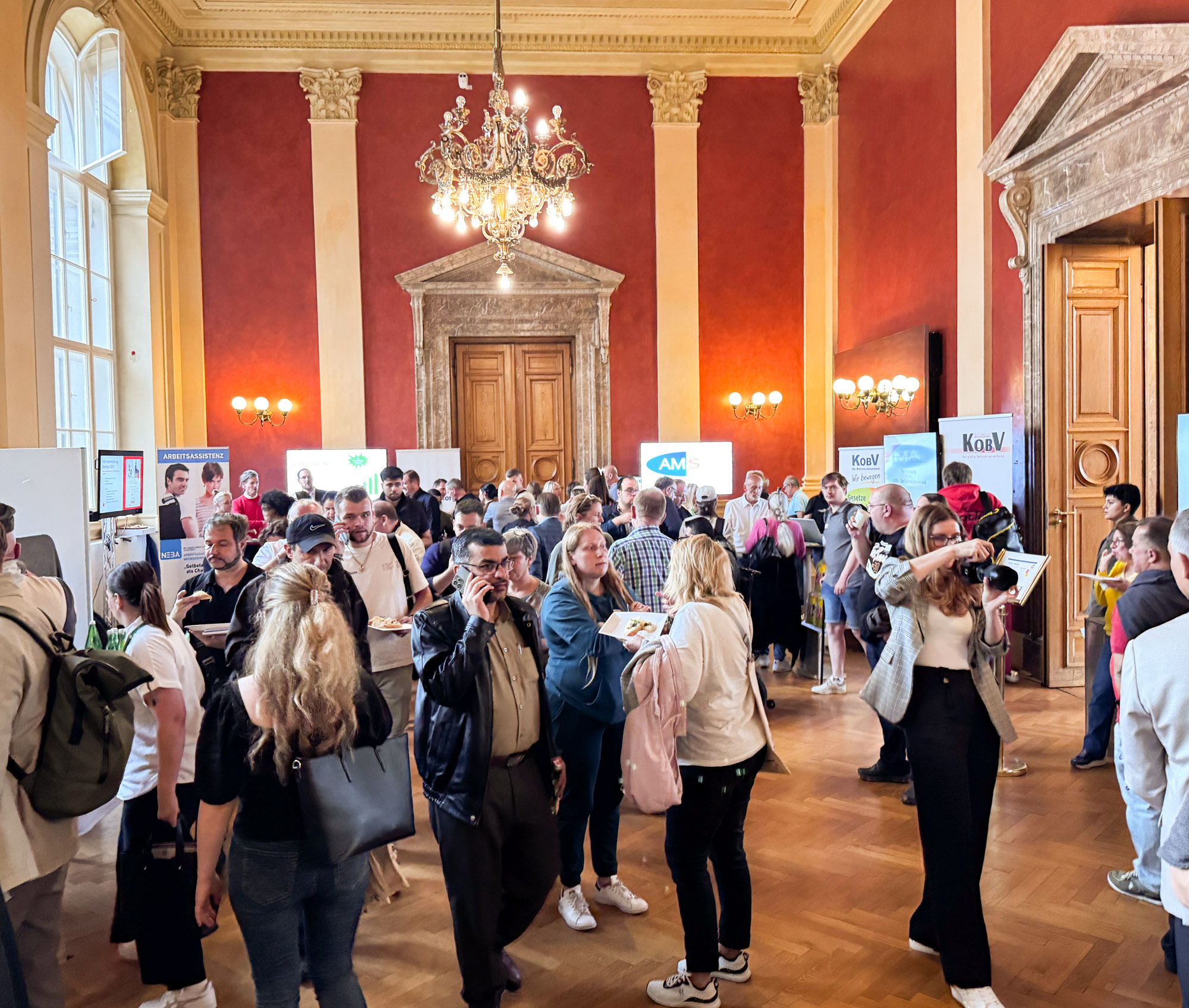 Ein Festsaal mit Informationsständen der Partner